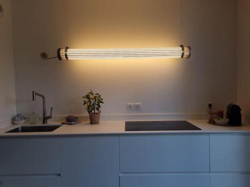 a kitchen with a sink and a light on the wall at Garden Alley House 8 personnes in Serris