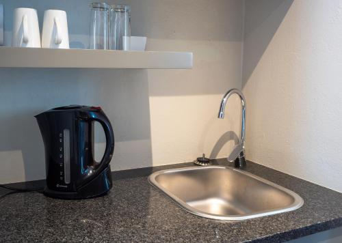 a coffee maker sitting next to a kitchen sink at Olifants River Lodge by Dream Resorts in Middelburg