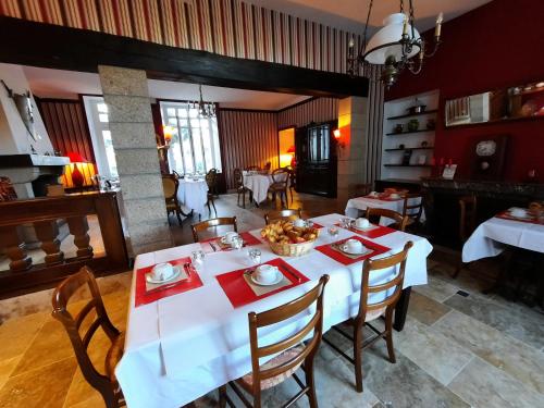 Un comedor con una mesa y sillas blancas. en Hôtel De La Barbacane, en Tiffauges