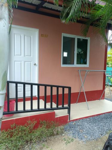 a house with a white door and a fence at Chill land house in Bang Tao Beach