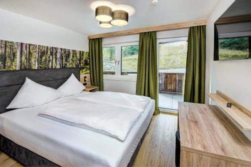 a bedroom with a bed and a table and windows at Das Förstereck in Viehhofen