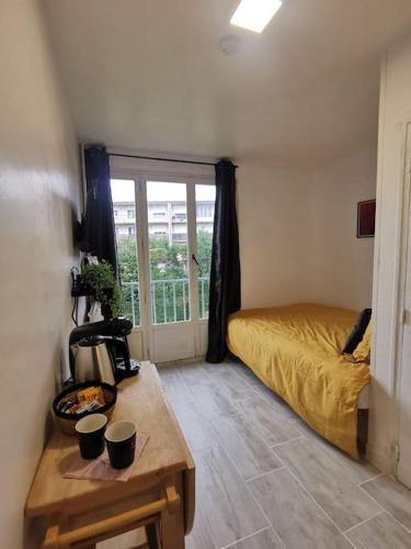 a bedroom with a bed and a table with cups on it at L'essentiel in Évreux