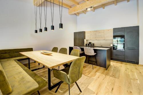 a kitchen and dining room with a wooden table and chairs at Das Förstereck in Viehhofen