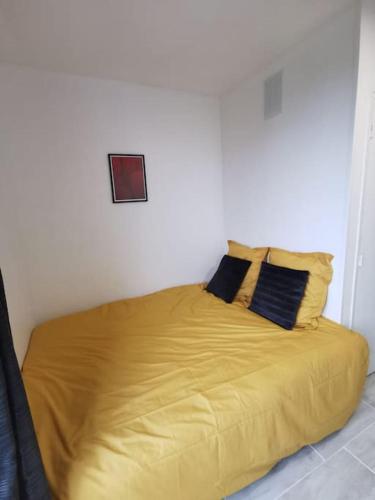 - un lit avec des draps et des oreillers jaunes dans l'établissement L'essentiel, à Évreux