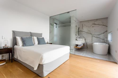 a bedroom with a large white bed and a bathroom at Ocean Blue in Paphos City