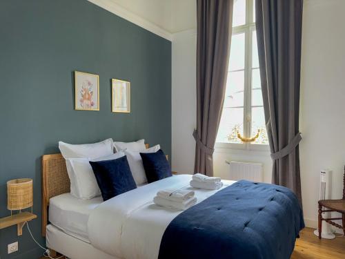 une chambre avec un lit aux murs bleus et une fenêtre dans l'établissement Hospice St Nicolas, à Troyes