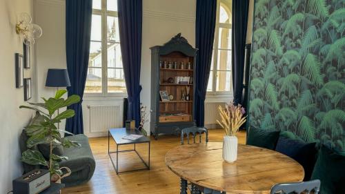 a living room with a table and a couch at Hospice St Nicolas in Troyes
