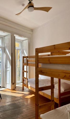 a bedroom with two bunk beds and a ceiling fan at Lisbon Chillout Hostel Privates in Lisbon