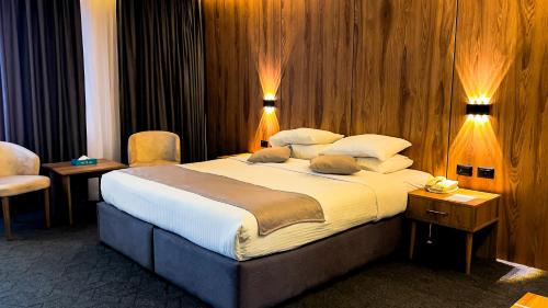 a large bed in a hotel room with two lights at Sandy palace Hotel in Amman