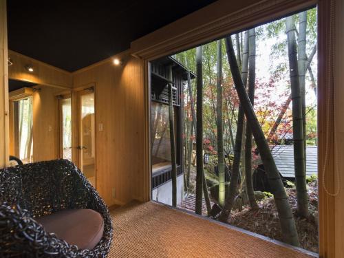 a room with a large glass window with a chair at Hikyou Shirakawagensen Sansou Takefue in Minamioguni