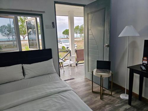 una camera con un letto e un computer portatile su un tavolo di Badungun Seaside View a Kuala Penyu