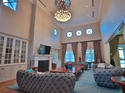 a large living room with couches and a chandelier at Chateau Crystal in Dullstroom