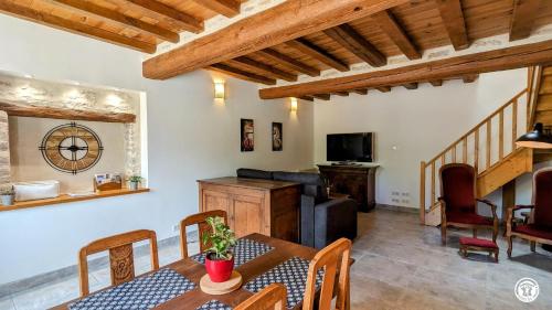 un soggiorno con tavolo, sedie e televisione di Au bout du Ciel - Maison avec garage, terrasse, cave a Savigny-lès-Beaune
