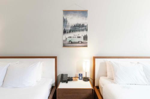a bedroom with two beds and a picture of a car at Adara Hotel in Whistler