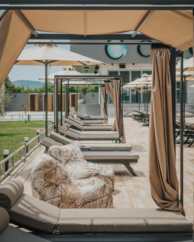 a row of chairs and umbrellas on a patio at Casino Motel Senator in Gevgelija