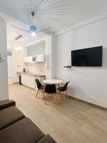 un salon avec une table et des chaises et une cuisine dans l'établissement #0 Appart proche du métro Robespierre et Paris 20, à Bagnolet