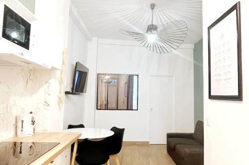 a white living room with a table and a couch at #0 Appart proche du métro Robespierre et Paris 20 in Bagnolet
