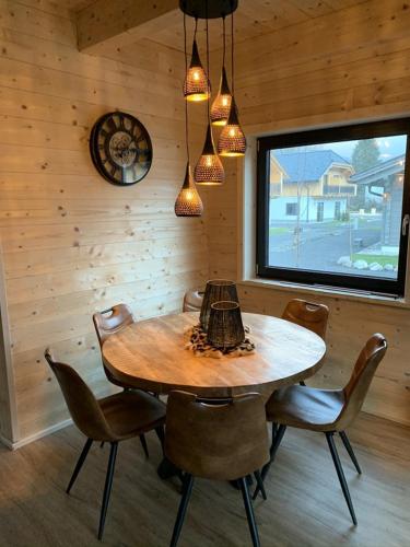 ein hölzernes Esszimmer mit einem Tisch und Stühlen in der Unterkunft Nassfeld Chalet A and B in Rattendorf