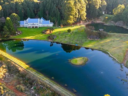 an aerial view of a house with a large lake at Chateau Crystal in Dullstroom