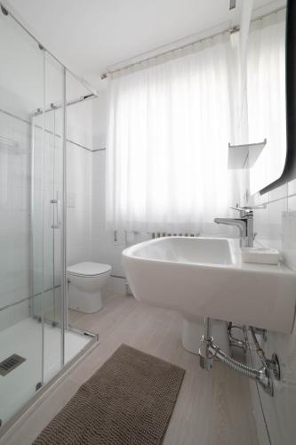a white bathroom with a sink and a toilet at la foglia verde in Pesaro