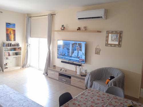 a living room with a flat screen tv on a wall at Xylophagou Rest and Relax 3 Ayia Napa Larnaca 1 bedroom apartment in Xylophaghou