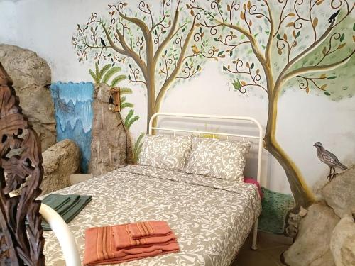 a bedroom with a bed with trees on the wall at Quinta do Castelo, Casa de Campo de Pedra in Reguengo Grande