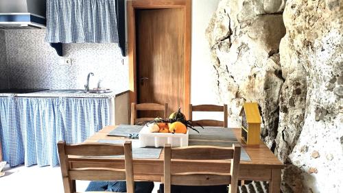 a dining room table with a bowl of fruit on it at Quinta do Castelo, Casa de Campo de Pedra in Reguengo Grande