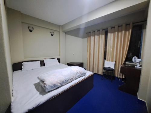 カトマンズにあるHotel Basantapurの大きなベッドと窓のある寝室