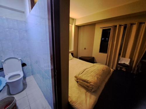 カトマンズにあるHotel Basantapurのベッドと窓のある小さな寝室