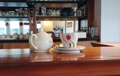 a table with two cups and a tea pot on it at Brit Hotel L'Arrivée Guingamp in Guingamp