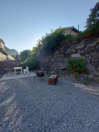 a stone wall next to a table and a bench at Old Town House in Rjukan