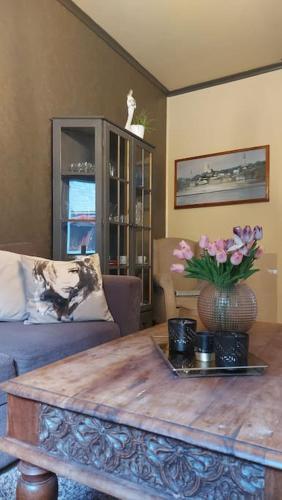 a living room with a coffee table with flowers on it at Old Town House in Rjukan