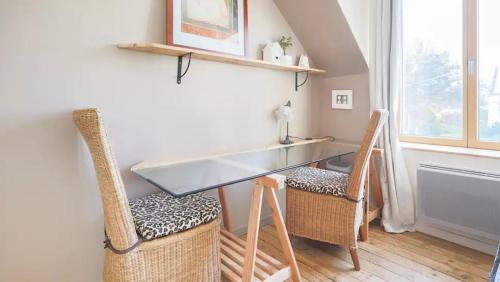 une table et des chaises en verre dans une chambre avec fenêtre dans l'établissement Chambre de charme sur le GR 34 et la vélo route maritime, à Saint-Brieuc