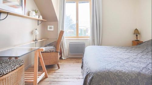 une chambre avec un lit, un bureau et une fenêtre dans l'établissement Chambre de charme sur le GR 34 et la vélo route maritime, à Saint-Brieuc