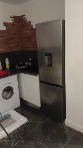 une cuisine avec un réfrigérateur et une machine à laver dans l'établissement Appartement alexis, à Corps-Nuds