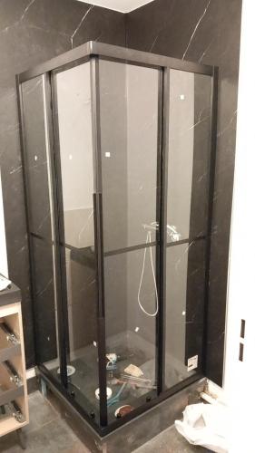 une cabine de douche en verre avec une porte en verre dans une salle de bain dans l'établissement Appartement alexis, à Corps-Nuds