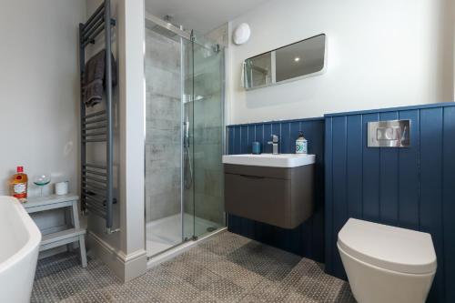 a bathroom with a shower and a toilet and a sink at North View cottage. Shaldon village. in Shaldon