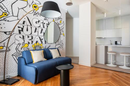 a living room with a blue couch and a wall mural at MIXT by Zoia Living in Athens