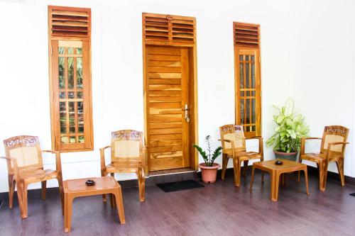 a group of chairs and tables in front of a door at Hotel Nilketha Yala Tissamaharama in Tissamaharama