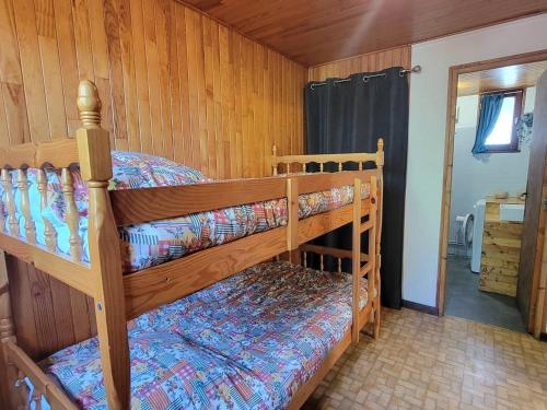 a bedroom with two bunk beds in a cabin at Appartement au RDC d'un Chalet - Proche Ski/Randonnées - Terrasse Sud - 4 pers - FR-1-393-150 in Saint-Michel-de-Chaillol