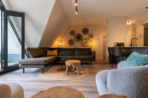 a living room with a couch and a table at Hello Zeeland - Appartement Duno Lodges 6 personen in Oostkapelle