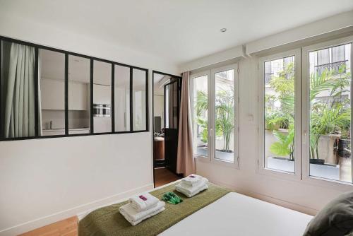 une chambre avec un lit et des fenêtres avec des serviettes dans l'établissement Magnificent apartment - 1BR-4P - Palais Royal, à Paris