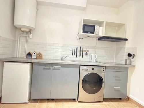 una cocina con fregadero y lavadora en 711 Appart versatile proche du Métro et Paris 20E, en Bagnolet
