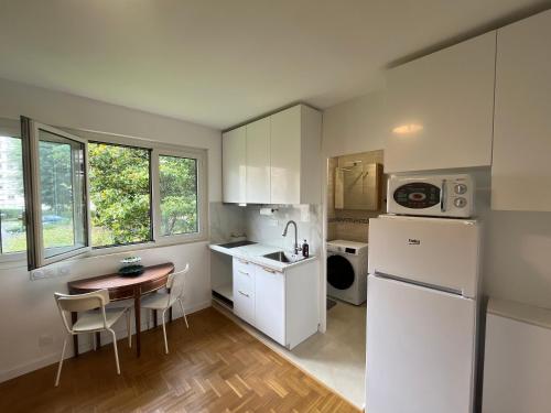 Una pequeña cocina con una mesa y un refrigerador. en Studio Honneur - Parc Sceaux, en Sceaux