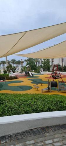 a painting of a playground with a park with tables at Apartment at Address Beach Resort Sharm Al Aqah in Fujairah