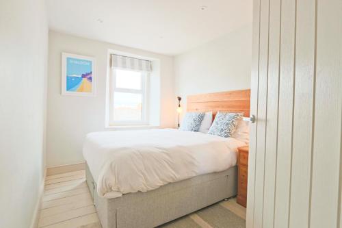 a bedroom with a large bed and a window at North View cottage. Shaldon village. in Shaldon