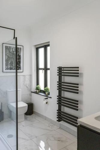 a white bathroom with a toilet and a window at Apartment in Altrincham Centre in Altrincham
