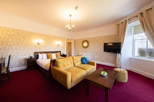 a hotel room with a bed and a couch at The Atholl Palace in Pitlochry