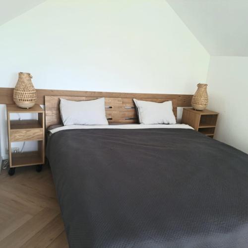 a bedroom with a large bed with a wooden headboard at Jūrmalciema Namiņi in Jūrmalciems