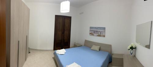a bedroom with a blue bed in a white room at La home di Antonio in Marsala